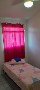 a bed with a pink curtain in a room at Casa duplex para lazer in Paulista