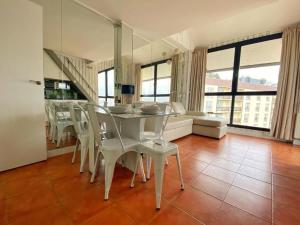 a dining room with a white table and chairs at Apartamentos Gorbea Suites in Sierra Nevada