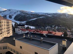 a view of a city with a snowy mountain at Apartamentos Gorbea Suites in Sierra Nevada