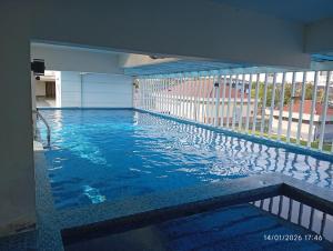 a large swimming pool with blue water in a building at Seberang Jaya Family Pool Homestay Near Hospital 3 Bedroom Aircond 2 Bathroom & Family Room Aircond in Perai