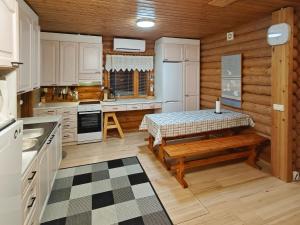 a kitchen with white cabinets and a table in a room at Holiday Home Saarenpää by Interhome in Koivisto