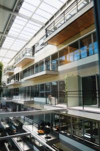 an office building with balconies and tables in therium at Atrium Studios by Xtay –Modern, Well-Located Studios, 9min from Arena Opus in Palhoça