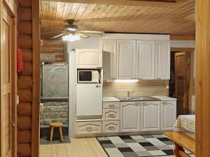 a kitchen with white cabinets and a refrigerator at Holiday Home Saarenpää by Interhome in Koivisto