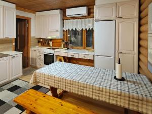 a kitchen with a table and a white refrigerator at Holiday Home Saarenpää by Interhome in Koivisto +16 photos