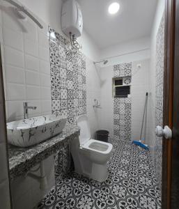 a bathroom with a sink and a toilet at Rosean Homestay Self Service Apartments in Candolim +85 photos