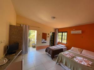 a hotel room with two beds and a television at Pousada Café do Brejo in Triunfo