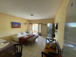 a hotel room with a bed and a living room at Pousada Café do Brejo in Triunfo