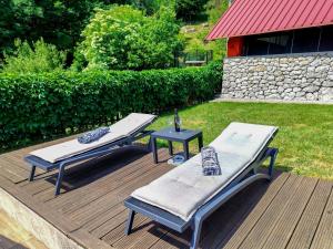 two beds and a table on a wooden deck at Holiday Home Maja by Interhome in Lič