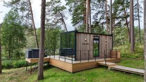 a tiny house in the woods with a deck at Bejas Lux Mirror Houses in Stūri