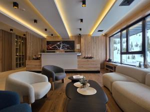 a living room with a couch and chairs and a tv at Horizont Aparthotel Jahorina in Jahorina +130 photos