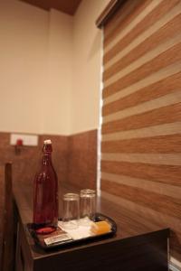 a tray with a bottle and two glasses on a table at Kovilakam Achutham in Guruvāyūr