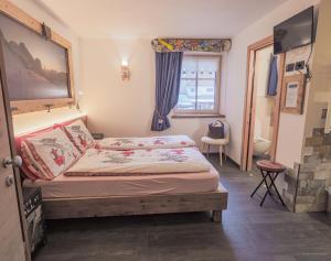 a small bedroom with a bed and a window at Majon de la nona in Pozza di Fassa +132 photos