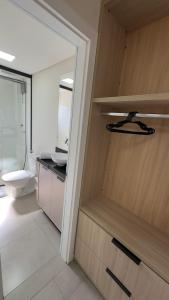 a bathroom with a toilet and a sink and a mirror at Studio 48 - Lindo apto Studio no centro de Foz in Foz do Iguaçu +156 photos
