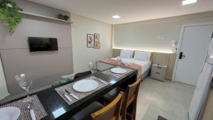 a hotel room with a bed and a table with two sinks at Studio 48 - Lindo apto Studio no centro de Foz in Foz do Iguaçu