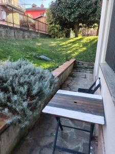 a wooden bench sitting on a patio with a lawn at Appartamento Sleep&Fly in Grassobbio