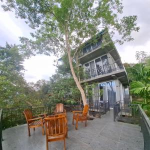 a house with chairs and a table and a tree at Highgarden Hideaway Villa - Gampola in Gampola
