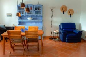 a dining room with a table and a blue chair at Vila Saraz Alqueva in Campinho