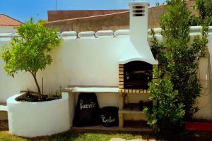 a pizza oven in the side of a building with two trees at Vila Saraz Alqueva in Campinho
