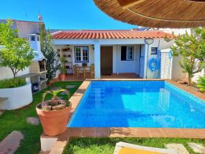 a swimming pool in front of a house at Vila Saraz Alqueva in Campinho