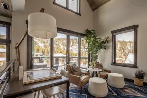 a living room with a table and chairs and windows at Spanish Peaks - Highlands Cabin 36 in Big Sky