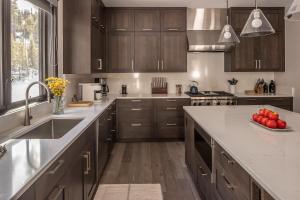 a kitchen with wooden cabinets and a sink and a counter top at Spanish Peaks - Highlands Cabin 36 in Big Sky +43 photos