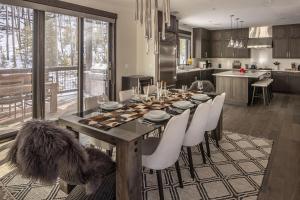 a dining room table with white chairs in a kitchen at Spanish Peaks - Highlands Cabin 36 in Big Sky