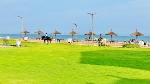 a group of people riding horses on the beach at Hotel Petit Brussel in Lomé