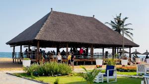 a large pavilion on the beach with people in it at Hotel Petit Brussel in Lomé +63 photos