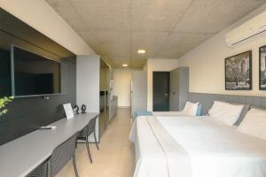 a hotel room with two beds and a desk at Moderno e Central - CA905 in Maringá