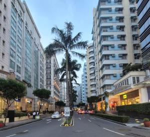 an empty city street with palm trees and buildings at Travellers 101 Condo near Manila Airport in Manila