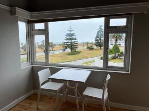a table and chairs in a room with a window at Bird Rock Sunrise in Gqeberha +26 photos