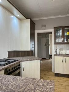 a kitchen with white cabinets and a counter top at Bird Rock Sunrise in Gqeberha
