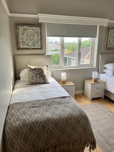 a bedroom with a bed and a window at Bird Rock Sunrise in Gqeberha