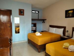 a hotel room with two beds with yellow sheets at Hotel Tres Flores in Huasca de Ocampo +33 photos