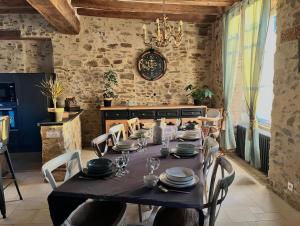 a dining room with a table with plates and dishes on it at La Pierre du Bonheur in Saint-Denis-dʼAnjou