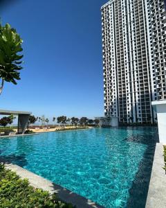 a swimming pool in front of a tall building at Batu Kawan Sunset Seaview Condo near Ikea & Design Village in Batu Kawan