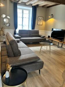 a living room with a couch and a table at La Pierre du Bonheur in Saint-Denis-dʼAnjou