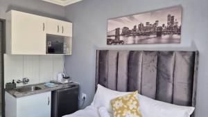 a bedroom with a bed and a sink and a picture at KeAnna STAYS units in Tsumeb