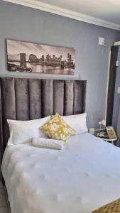 a bedroom with a white bed with a picture on the wall at KeAnna STAYS units in Tsumeb