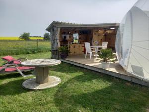 a wooden deck with a table and a tent at La chevauchée vers les étoiles in Yèvres