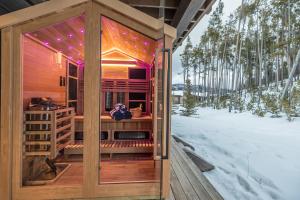 a wooden sauna with purple lights in the snow at Spanish Peaks - Highlands Cabin 36 in Big Sky