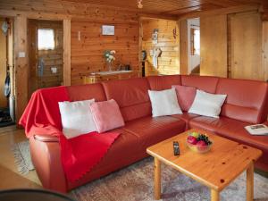 a brown leather couch in a room with a table at Chalet Kil-Ukru by Interhome in Ovronnaz