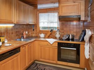 a kitchen with wooden cabinets and a sink at Chalet Kil-Ukru by Interhome in Ovronnaz +26 photos