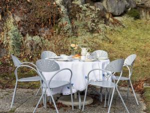 a table with a white table cloth and chairs at Chalet Kil-Ukru by Interhome in Ovronnaz