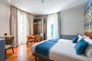 a bedroom with a large bed with blue pillows at Hotel Astoria in Rapallo +20 photos