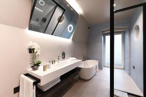 a bathroom with a large white sink and a tub at Hotel Astoria in Rapallo