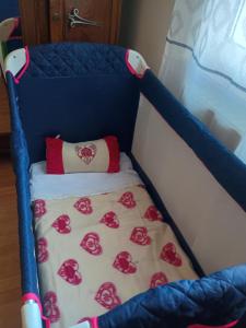 a blue crib with a blanket with red roses on it at Andrée in Lapalisse