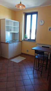a kitchen with a table and a clock on the wall at Tenuta Rio del Sole-Camera singola in Albairate +3 photos