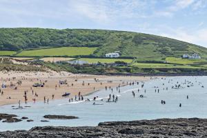 a group of people standing in the water at a beach at 3 Bed in Croyde oc-2ingle in Croyde