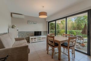 a living room with a table and a couch at Les Sarments in Le Lavandou